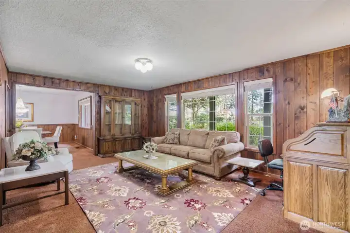 Cozy formal living room that looks out onto the lush front landscape.