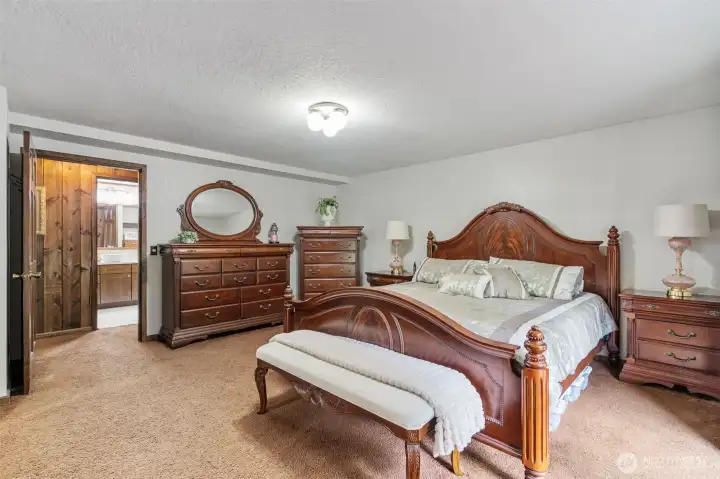Grand primary bedroom with newly remodeled private bathroom right across the hall.  That is a king sized bed and large dressers and nightstands.  There is still room to move.