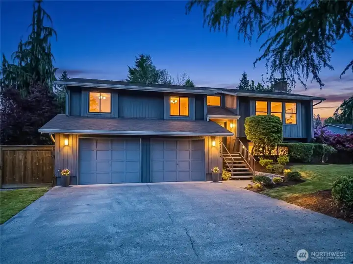 Twilight of the front, showing room for at least 4 additional cars on the driveway.