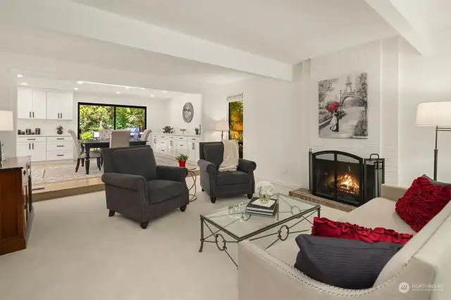 The living room features beamed ceilings, and a full-height brick wood-burning fireplace