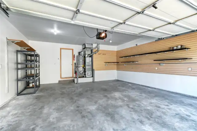 Garage with shelving and additional built-in storage above the garage door.