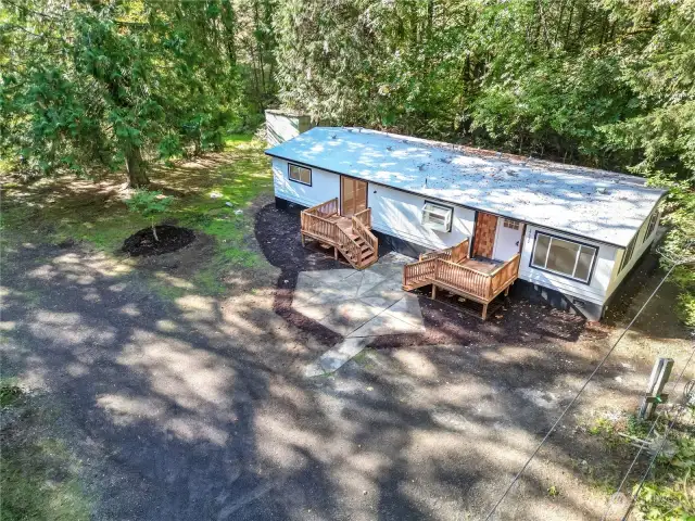 Second view of newly updated home inside and out with 3 new decks ext paint new roof electrical cedar siding and  and modern updates inside.  There is room to build shop garage and add other rental units around home for perfect investment