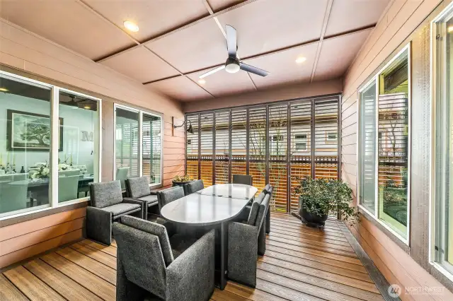 Covered side deck in between dining room and great room makes for a wonderful bonus space (not counted in square feet) with plantation shutters to keep out the elemens or let the breeze in.