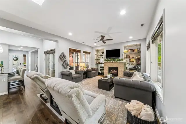 Great room with kitchen island, covered side deck, dining room and entry way in view.