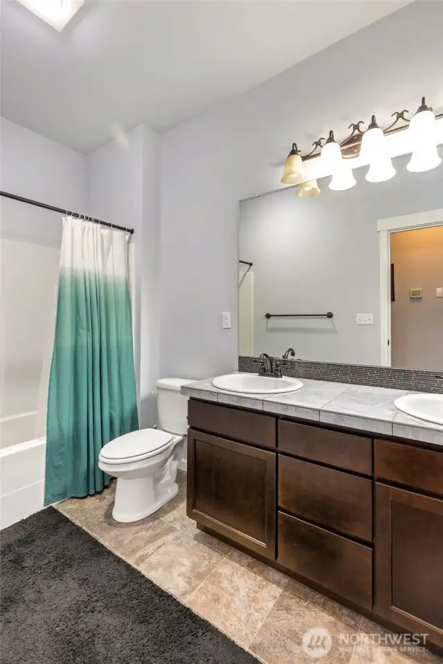 Hall Bath with 2 sinks and stone tile