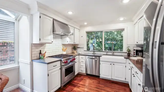 Refined kitchen showcasing quartz countertops, designer tile backsplash, and high-end appliances including Bosch dishwasher, LG refrigerator, Wolf 4-burner gas cooktop and oven.