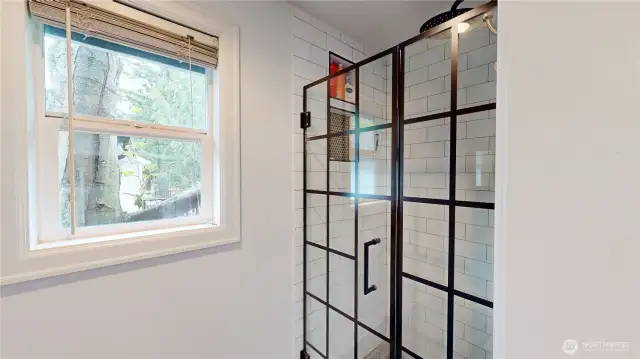 Primary shower features large subway tile and decorative glass door enclosure.