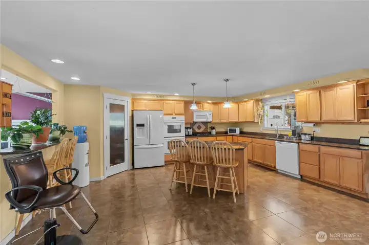 Kitchen on the upper level features an island bar and also a 2nd bar eating area at the pass through to the dining room. There's even space for an additional small table if you desire.