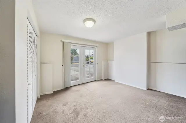 Additional bedroom on the lower level with French Door access from the driveway. Washer and Dryer are in the closet to the left. (virtual staging removed items stored in this room)