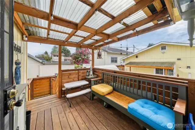 Covered back deck leads to the backyard and detached garage.