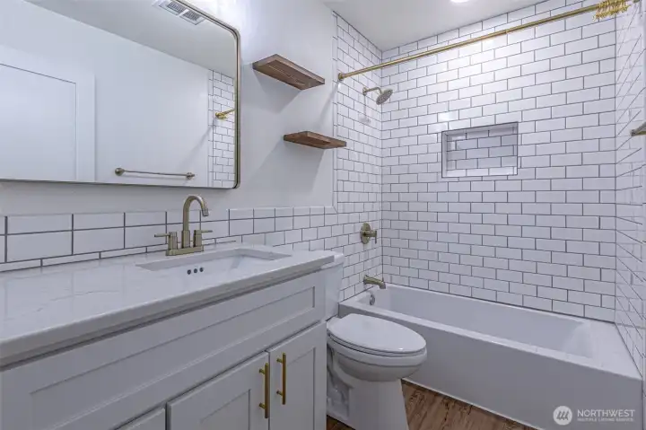Hall bath with tiled bathtub surround.