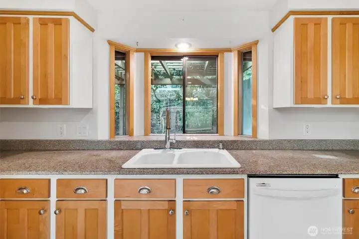 Bay window in kitchen provides views to natural landscape.