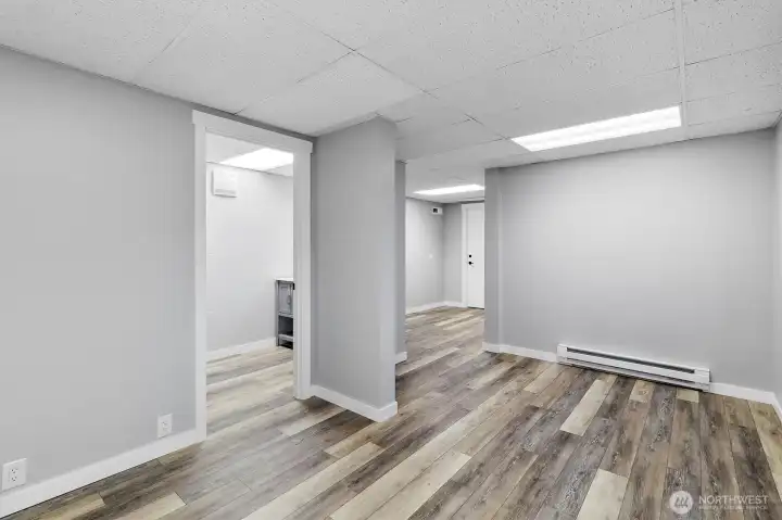 Finished basement flex space with adjacent half bathroom.