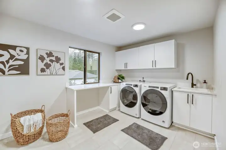 Large second floor laundry room with sink and tons of storage space