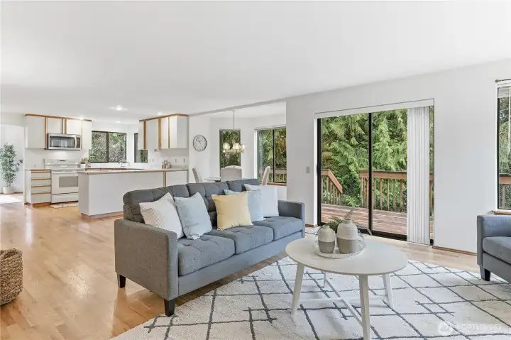 The family looking towards the kitchen and casual dining area. Slider provides direct access to the backyard and a expansive deck that connects to the dining room, expanding your options for seamless indoor-outdoor entertaining.