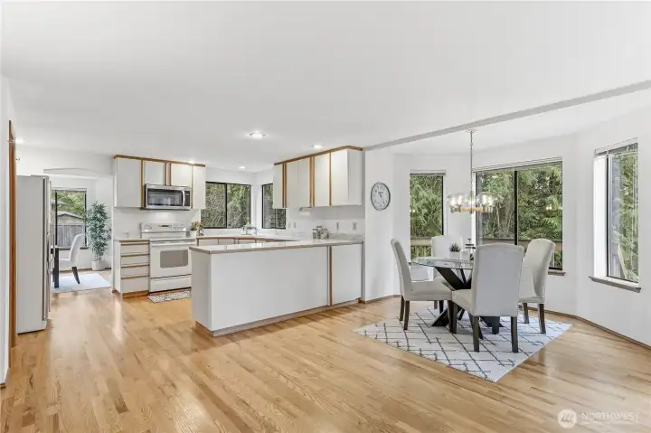 The spacious eating area with bay windows overlooks the deck and private backyard.