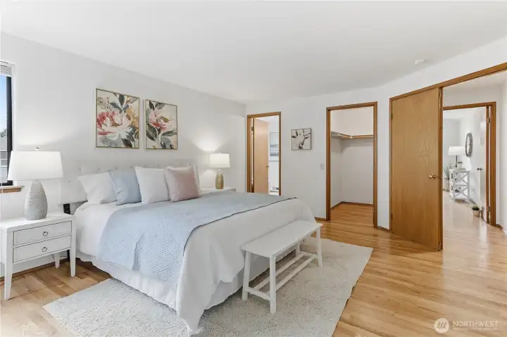 Primary suite looking towards the hall, walk-in closet, and primary bath.