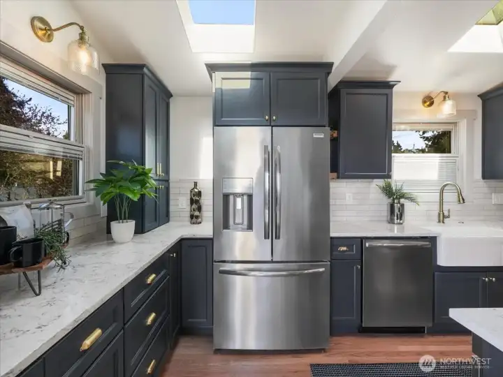 Abundance of custom cabinetry includes convenient pullouts for easy organization complemented by stylish Rejuvenation hardware.