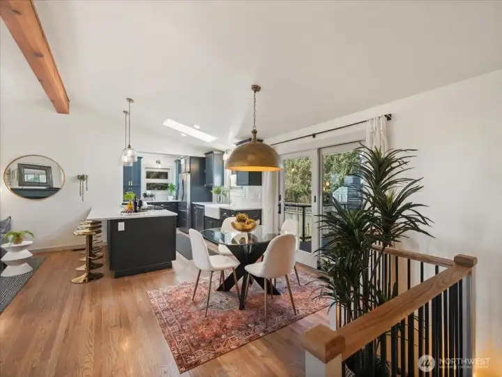 The dining area opens to the expansive open-concept living spaces, featuring a beautiful new light fixture that casts a warm welcoming ambiance.