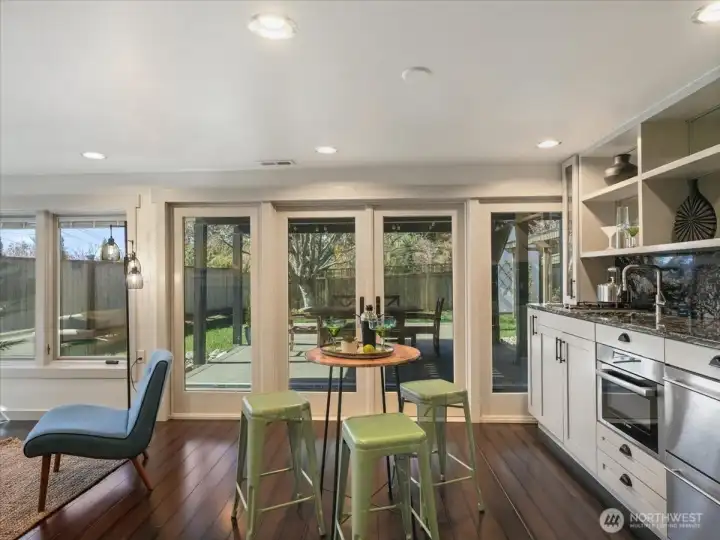 This space includes a well-appointed kitchenette featuring a two-burner cooktop, dishwasher, and sleek two-drawer refrigerator, sink and microwave—perfect for hosting guests with ease.  This level seamlessly blends indoor comfort with outdoor living, creating a private retreat for relaxation or gatherings.