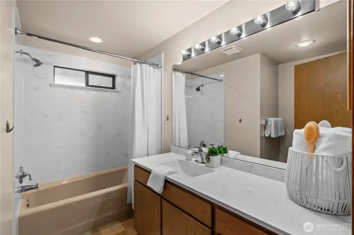 The hall bathroom features a large vanity with plenty of storage space.