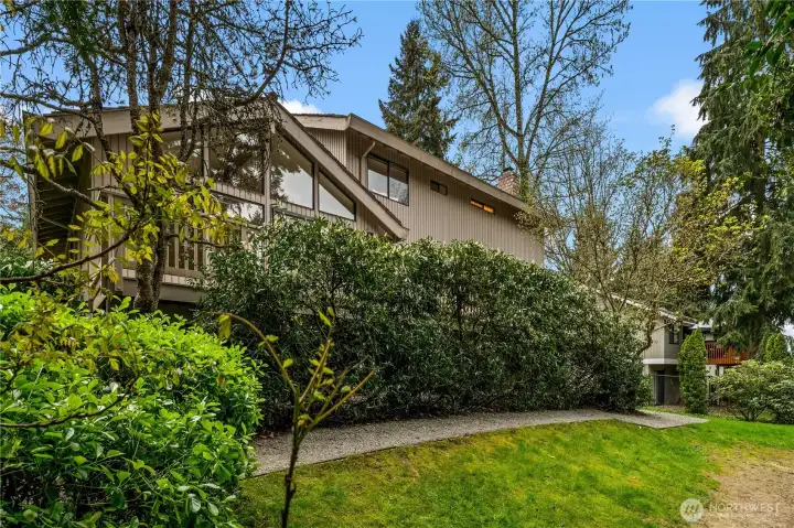 A gravel path winds through the park-like setting and leads to the spacious backyard.