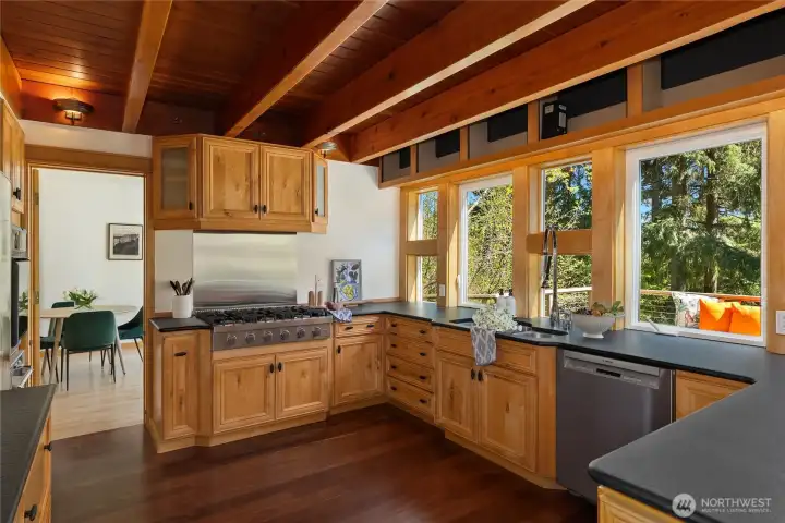 Australian red iron bark hardwood floors accentuate the kitchen wrapped in leathered granite countertops with stainless appliances including a 6-burner cooktop and Bosch dishwasher.