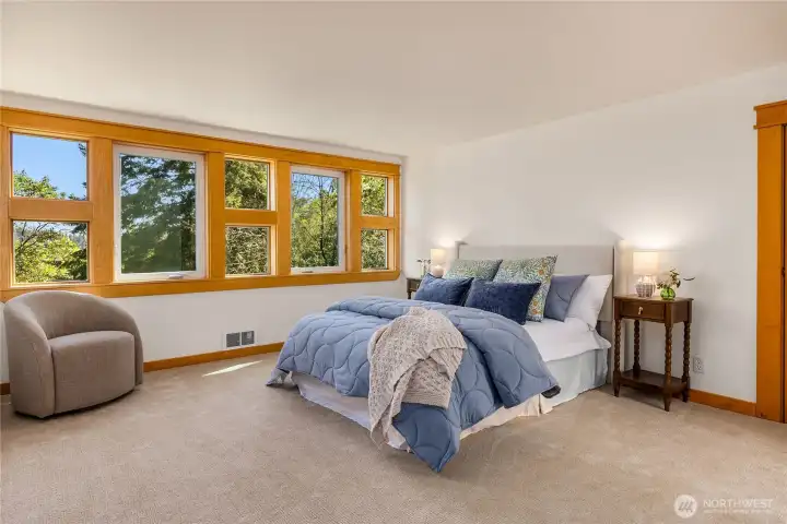 The top floor is devoted to the primary suite, filled with natural light from expansive windows.
