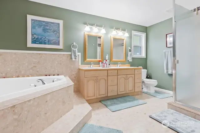 Primary bath with marble surround and jetted tub