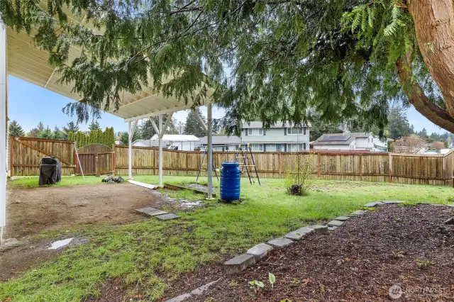 ~View of fully fenced backyard with RV parking and playset~