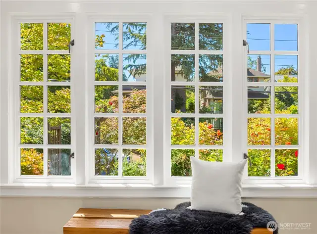 Gorgeous windows frame views of the thriving, rose-filled front garden, bathing the foyer in natural light and ever-changing color.