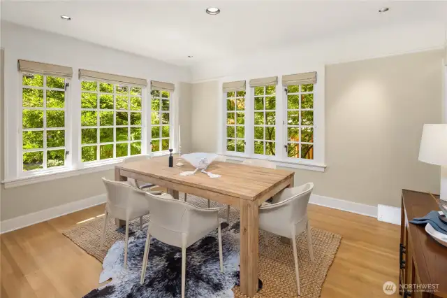 Large corner windows wrap the dining room in greenery.