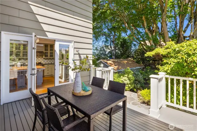 Easy access from the kitchen opens to a freshly painted deck — perfect for al fresco dining under the canopy of mature trees.