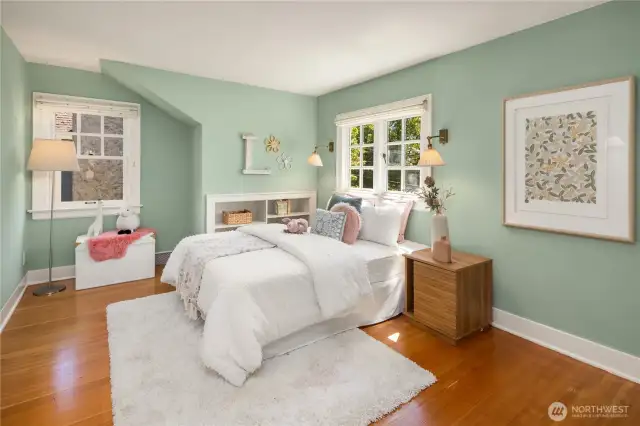 Sunlight, gleaming fir floors, and charming built-ins give this upstairs bedroom a warm, welcoming feel.