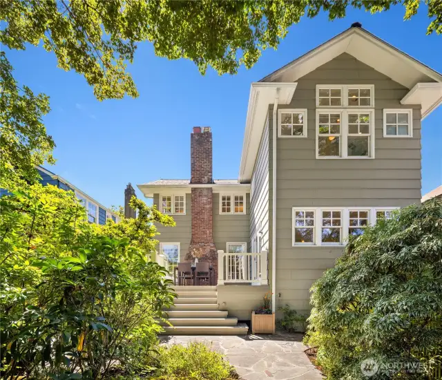 A stunning view of the home from the backyard—elegant, timeless, and framed by lush greenery.