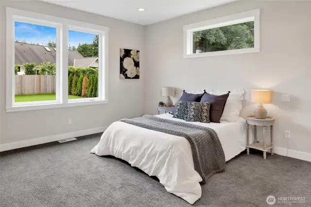 The primary bedroom retreat features a spacious en-suite bath with a walk-in closet, double sink vanity, large-format tile, frameless shower door, and a luxurious soaker tub—perfect for unwinding after a long day.