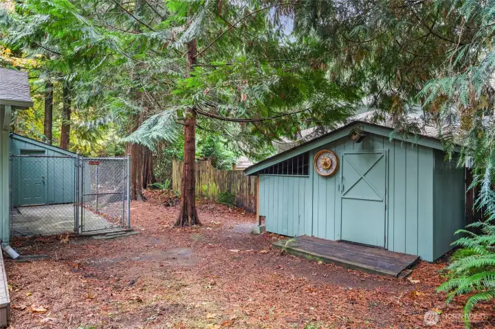Garden shed with covered, fully stocked wood shed off to the side. Also note dog kennel area off garage