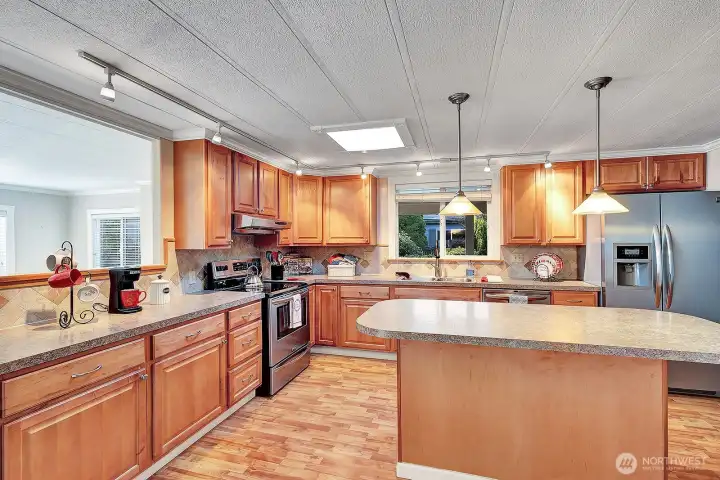 Chefs designed kitchen. Custom designed cabinetry. Added feature of lighting under the upper cabinets for your convenance. Stainless steel appliances. Double sink with custom faucet has garden view from window.  Island has lower storage and custom lighting. Easy care engineered flooring. Family room just steps away.