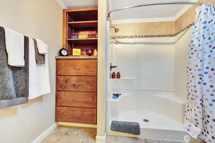 Sparkling clean step in seated shower for your convenience. Built in custom dresser for all bath linens etc.