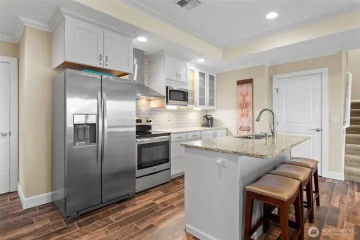 The stove/oven, refrigerator/freezer, microwave and dishwasher in this second kitchen are all included in the sale. The door next to the stairs has deep (under the stairs) storage, and the door to the left of the refrigerator leads to a 6' x 22' storage area which also houses the water heater & furnace.