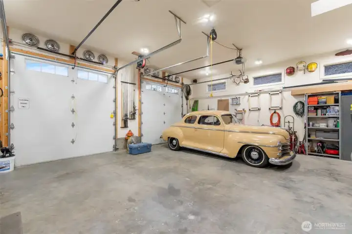 In addition to the attached 2 car garage, there is a three-bay 1128 sq ft garage with shop and half bath. These two doors are 10' tall. Another bay to the left is accessed separately. House has 400 am service; shop has 200 am service.