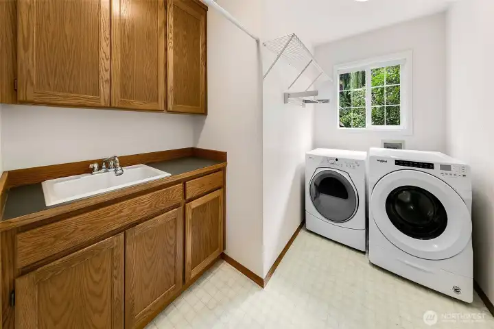 Main level laundry with utility sink and cabinet storage