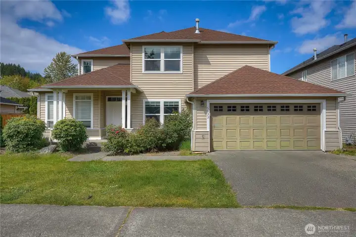 Located in a quiet residential neighborhood. The exterior features warm neutral siding, a well-maintained roofline, and a spacious two-car garage with decorative window accents. A covered front porch creates a welcoming entry, while mature landscaping and green lawn space add charm and privacy. Large windows throughout the home bring in natural light and enhance the clean, classic Northwest-style design. The extended driveway and functional layout offer both convenience and everyday comfort.
