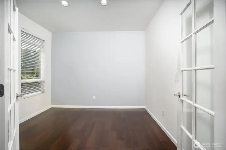 Versatile main-level flex space featuring elegant glass French doors, rich hardwood flooring, and abundant natural light. Perfect for a home office, guest room, study, playroom, or creative space, this room offers privacy while still feeling open and connected to the rest of the home. Neutral colors and clean finishes create a bright, functional area ready to fit your lifestyle needs.