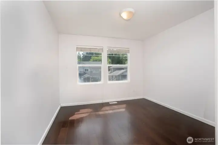 Third bedroom featuring rich flooring, natural light, and flexible space ideal for guests, a home office, or growing household needs.