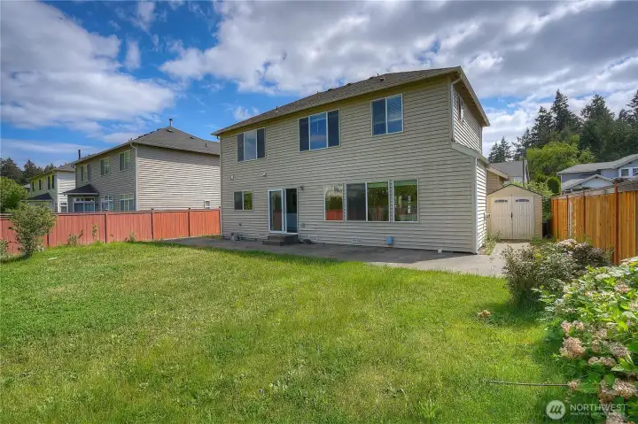 Fully fenced backyard with plenty of usable space for outdoor entertaining, pets, play, gardening, and summer BBQs, plus additional storage with an outdoor shed.