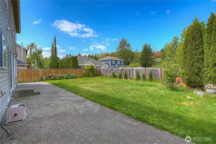 Spacious backyard with mature landscaping, established greenery, and plenty of room to expand your garden, add planter beds, or create your own outdoor retreat.