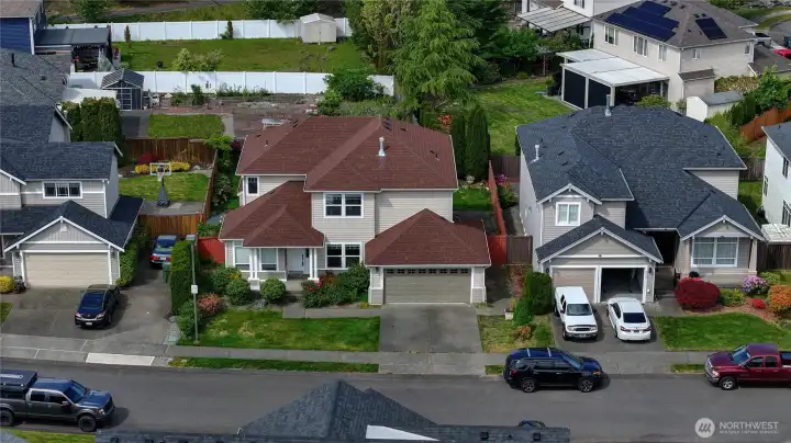 Aerial view showcasing the home’s spacious lot, mature landscaping, and convenient neighborhood setting.