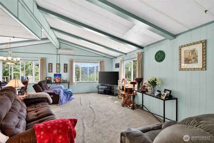 Great room w/vaulted ceilings looking into the dining area.