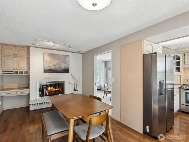 Elegant dining room with fireplace, beautiful engineered hardwoods, and kitchen nook.